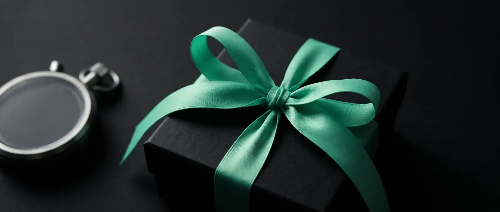 Miętowa wstążka na czarnym pudełku w zbliżeniu - przygotowanie kampanii e-commerce przed Black Friday